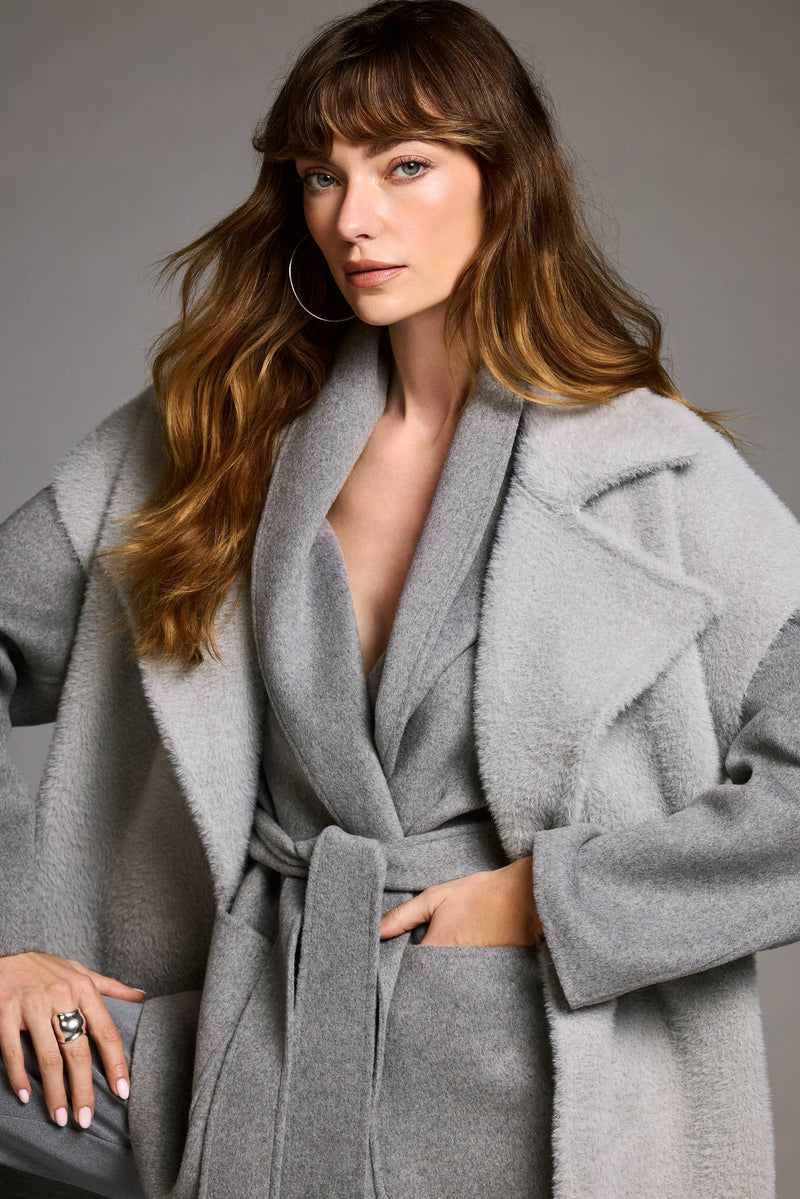 Grauer Wollmantel mit breitem Kragen und Bindegürtel – minimalistischer Stil in Studioaufnahme