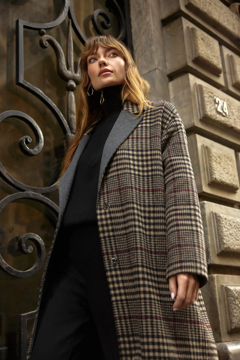 Karierter Mantel in Schwarz-Braun über schwarzem Outfit – eleganter Streetstyle-Look vor historischer Türkulisse