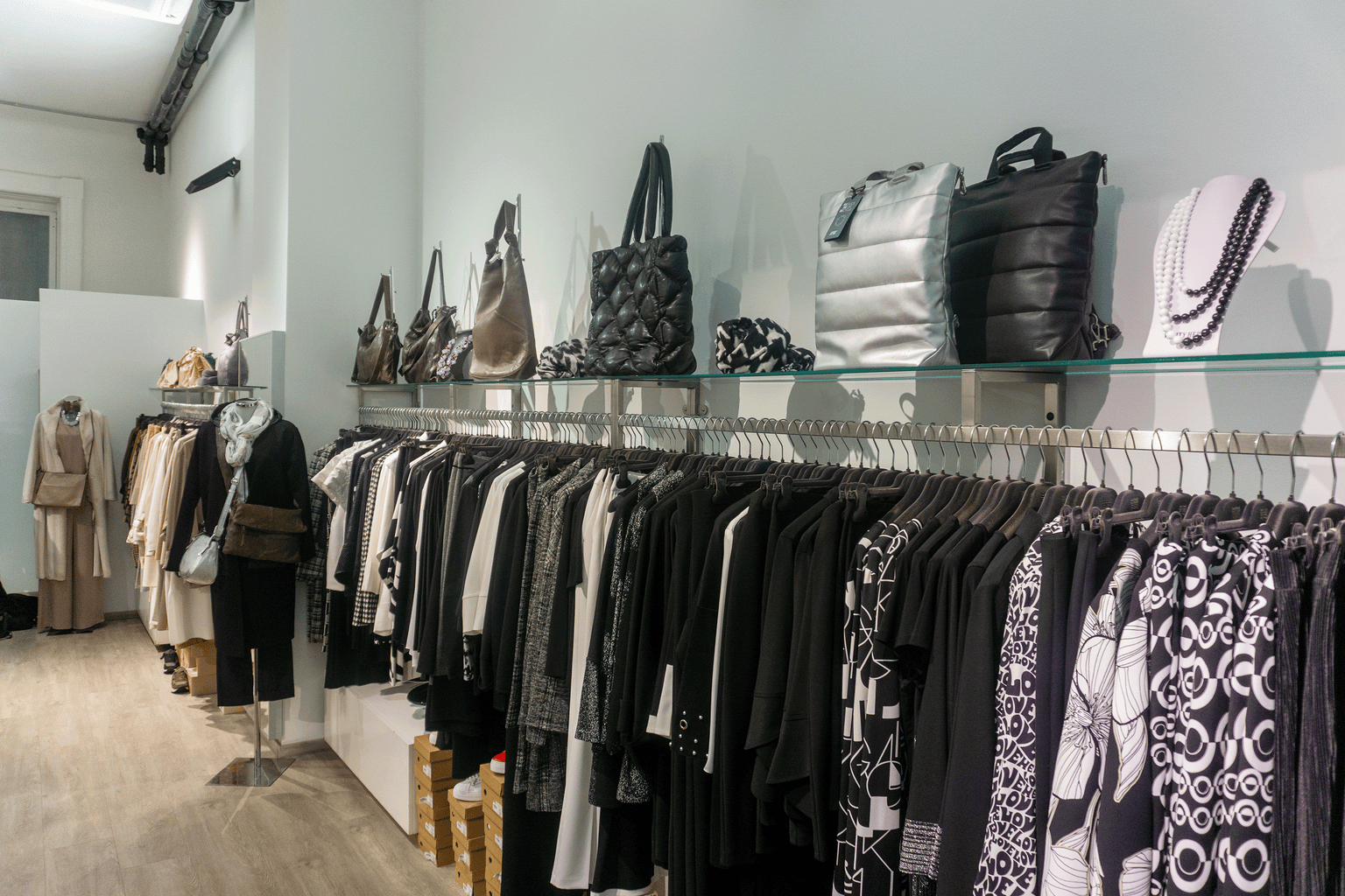Joseph Ribkoff Flagship Store Wien Innenansicht mit Damenmode in Schwarz, Weiß und Beige aus feinen Stoffen sowie Blazern, Kleidern und gemusterten Ensembles, dazu Taschen aus Leder und gestepptem Material in elegantem Boutique Ambiente