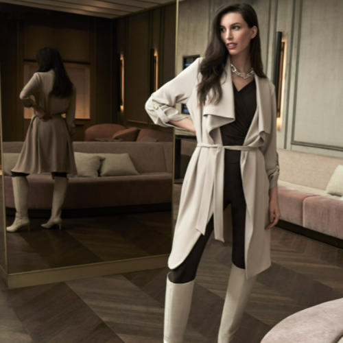 Model steht in einer Hotellobby und possiert in einem schwarz weißem Outfit